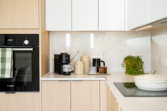 A kitchen with a black oven and wooden cabinets.
