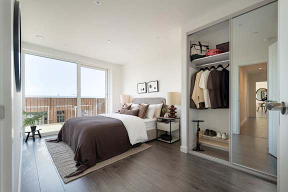A bedroom with a large bed and a balcony.
