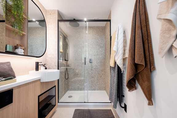 A bathroom with a walk-in shower and a towel rack.