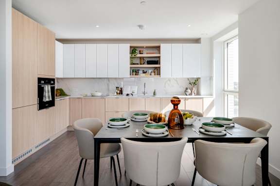 A modern kitchen with a dining table set for four.