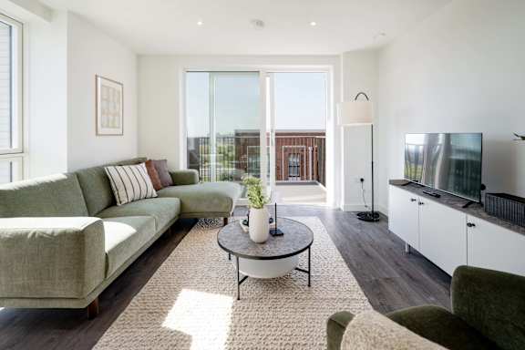 A living room with a couch, a coffee table, and a television.