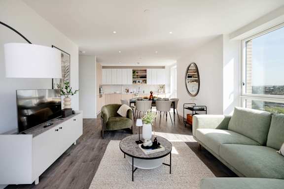 A modern living room with a green couch and a coffee table.