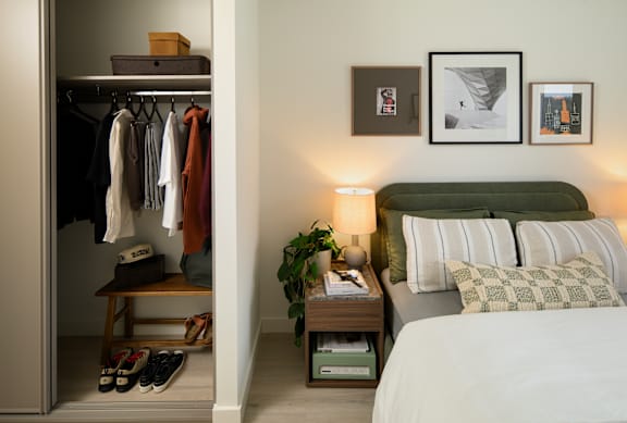A bedroom with a bed, a window with curtains, and a picture hanging on the wall.