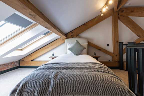 A bedroom with a bed covered in a striped comforter.