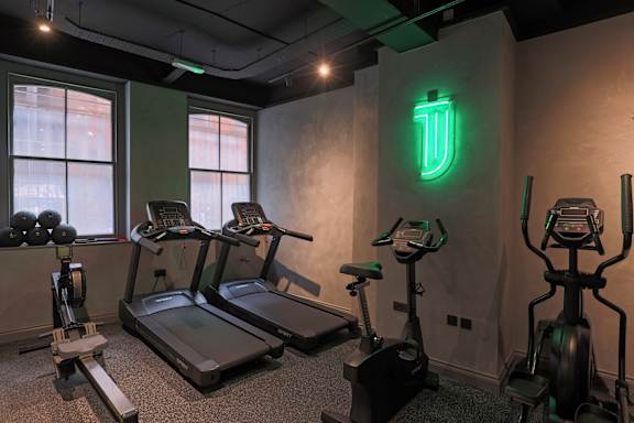 A gym with treadmills, exercise bikes, and weights.