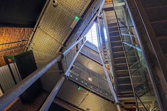 A staircase with a metal railing and a glass balustrade.