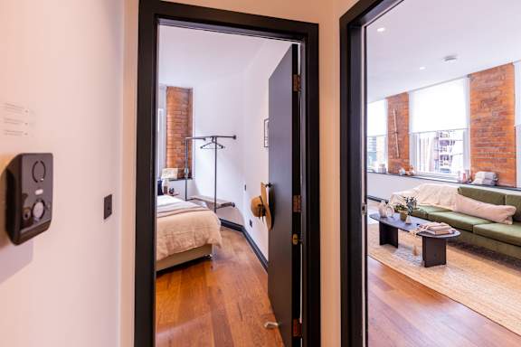 A room with a bed and a couch is visible through an open door.