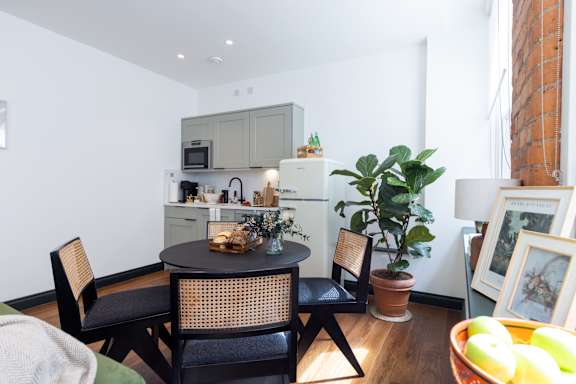 A kitchen with a table and chairs.