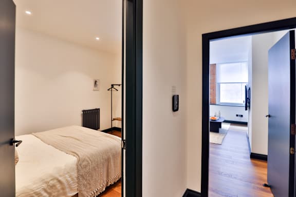 A bedroom with a bed and a mirror on the wall.