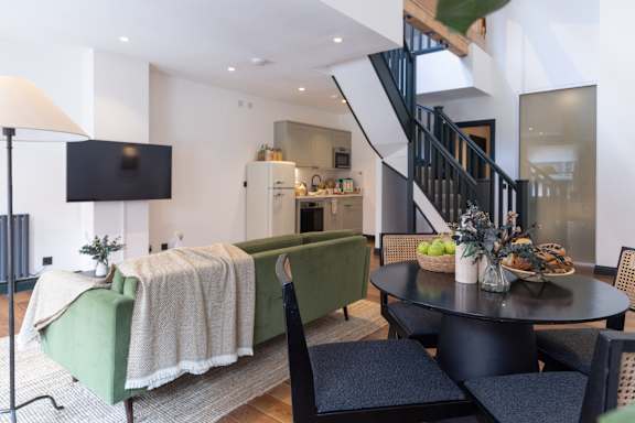 A living room with a green couch and a television.