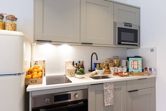 A kitchen with a white refrigerator, a microwave, and a sink.