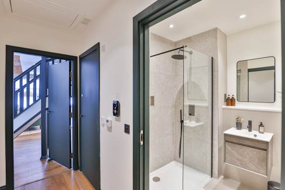 A modern bathroom with a walk-in shower and a vanity.