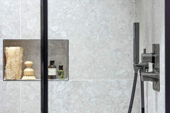 A bathroom with a mirror and a shower.