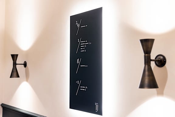 A black poster with mathematical equations is hanging on a wall.