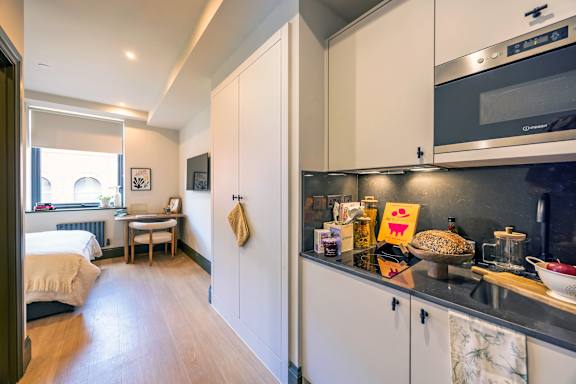 A kitchen with a microwave oven on the counter.