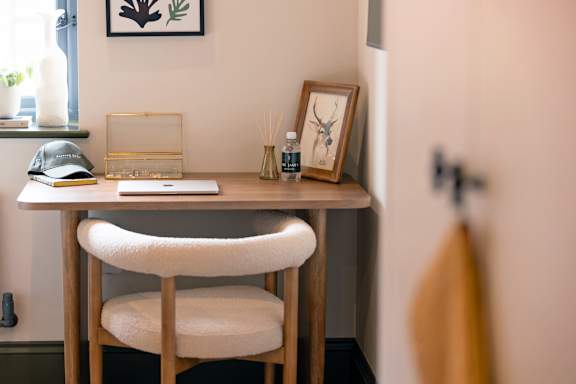 A wooden desk with a chair and a picture frame on it.