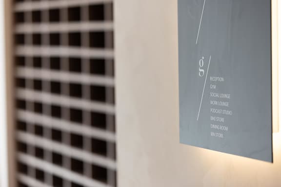 A sign with the word reception on it hangs on a wall.