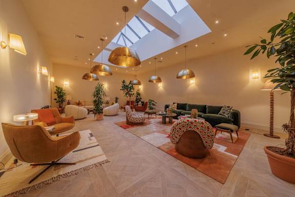 A spacious living room with a skylight and a variety of seating options.