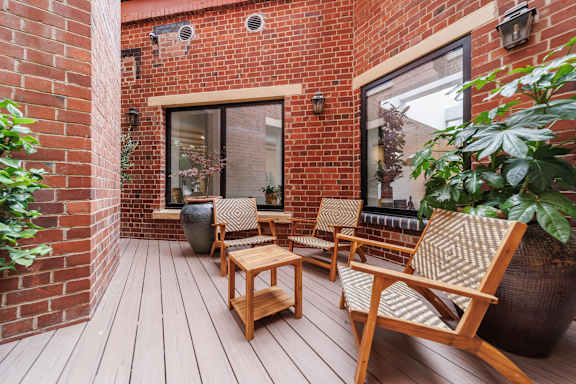 A wooden chair and table are on a wooden deck.