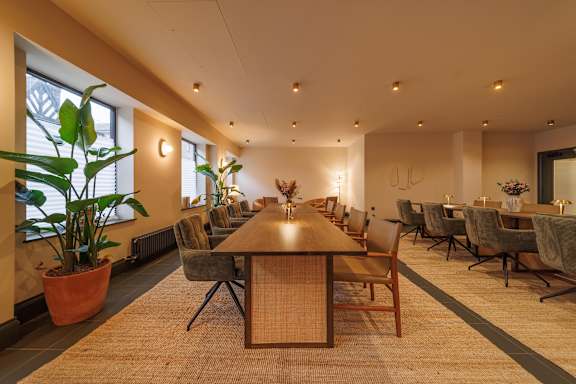 A conference room with a long table and chairs.