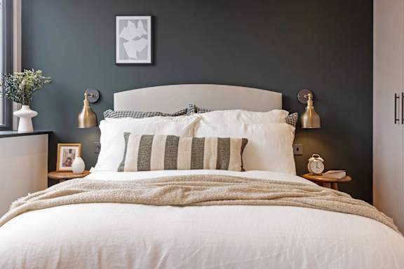 A bed with a white comforter and striped pillows is in the image.