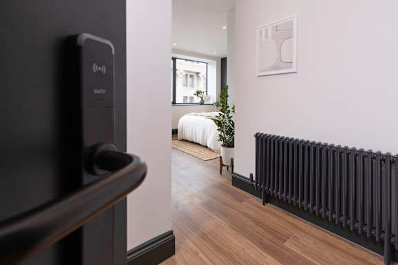 A black radiator is on the wall in a room.