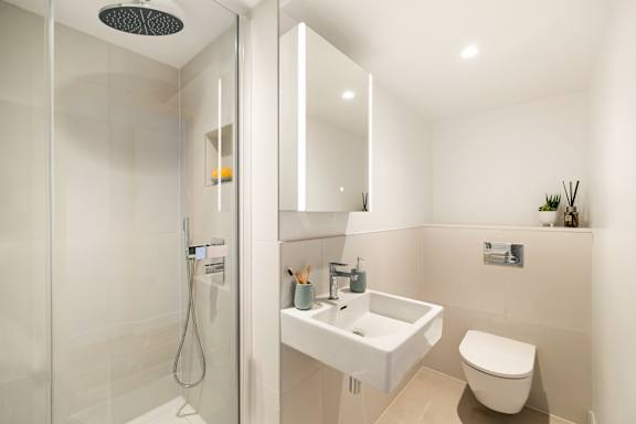 A modern bathroom with a white sink and toilet.