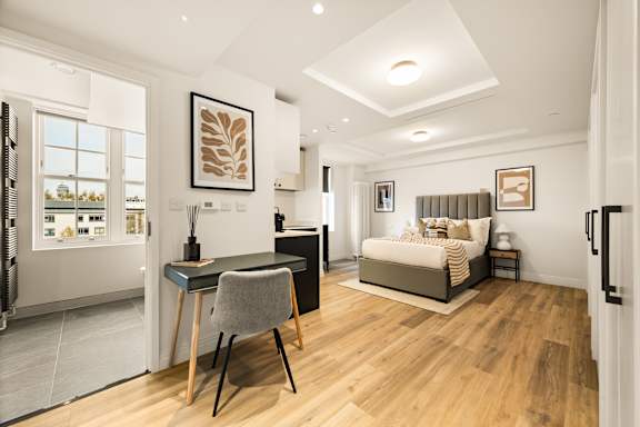A modern bedroom with a large bed and a desk with a chair.
