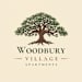 A logo for Woodbury Village Apartments featuring a tree.