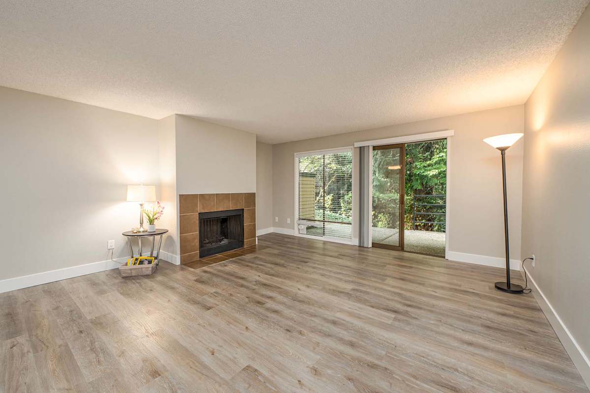 The Regent at Bellevue Way Apartments living room with fireplace and balcony door - Bellevue, WA