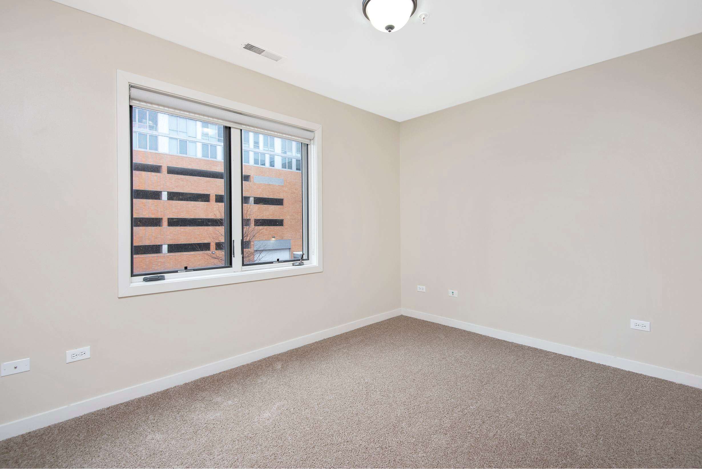 Oak Park Place apartment room with window and carpet - Oak Park, IL