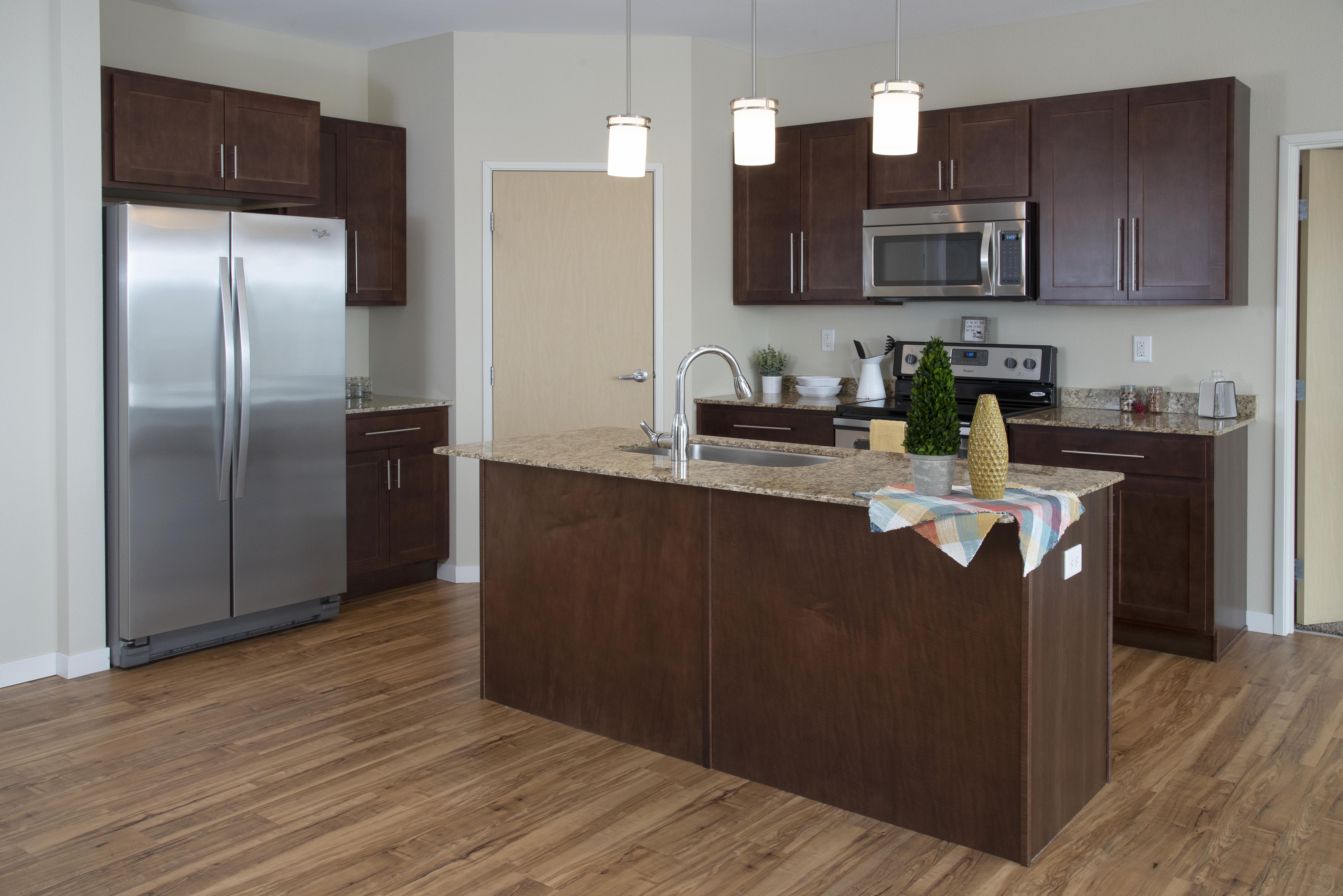The Gardens Apartments kitchen with island and stainless steel appliances - Grand Forks, ND