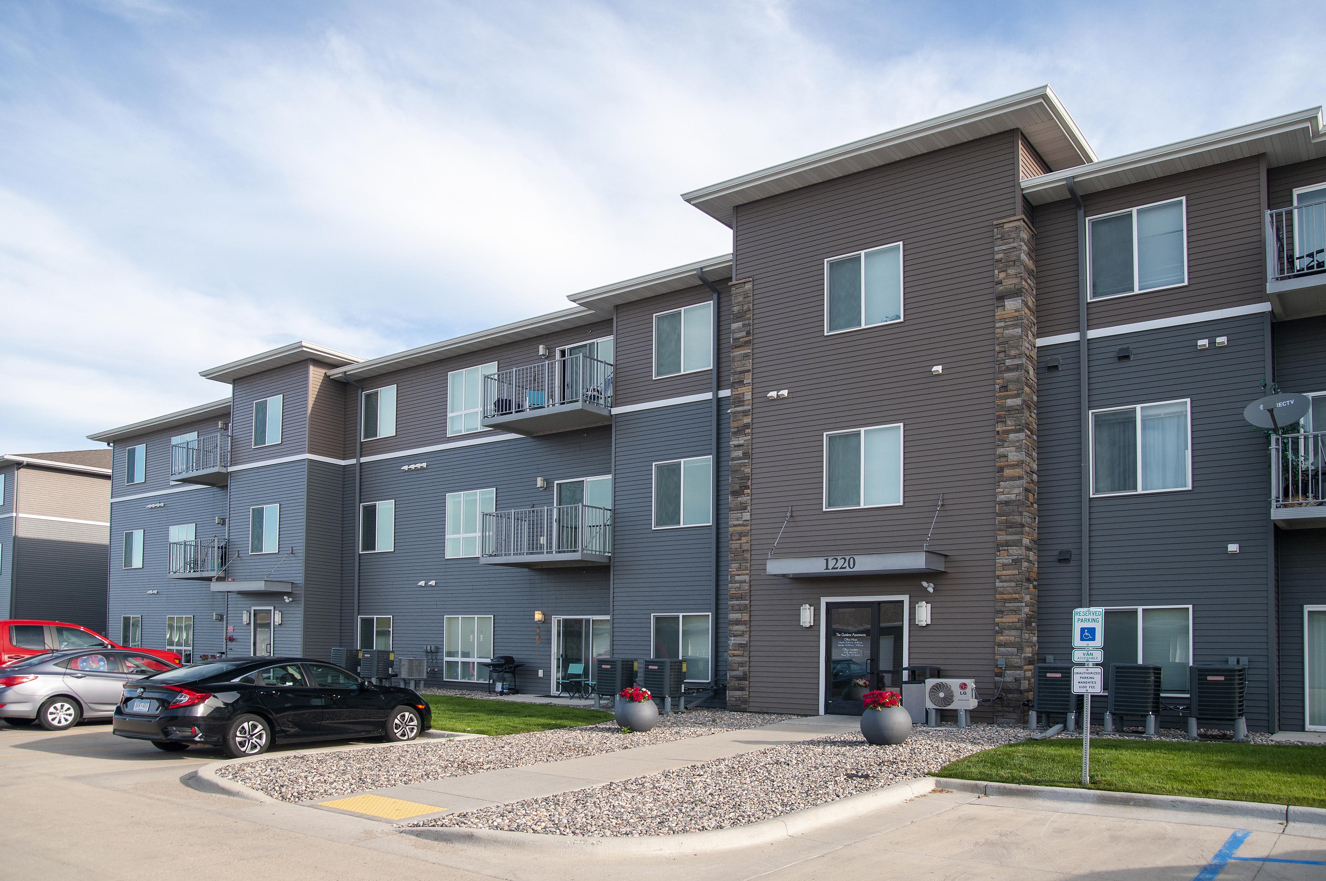 The Gardens Apartments exterior entrance and parking - Grand Forks, ND