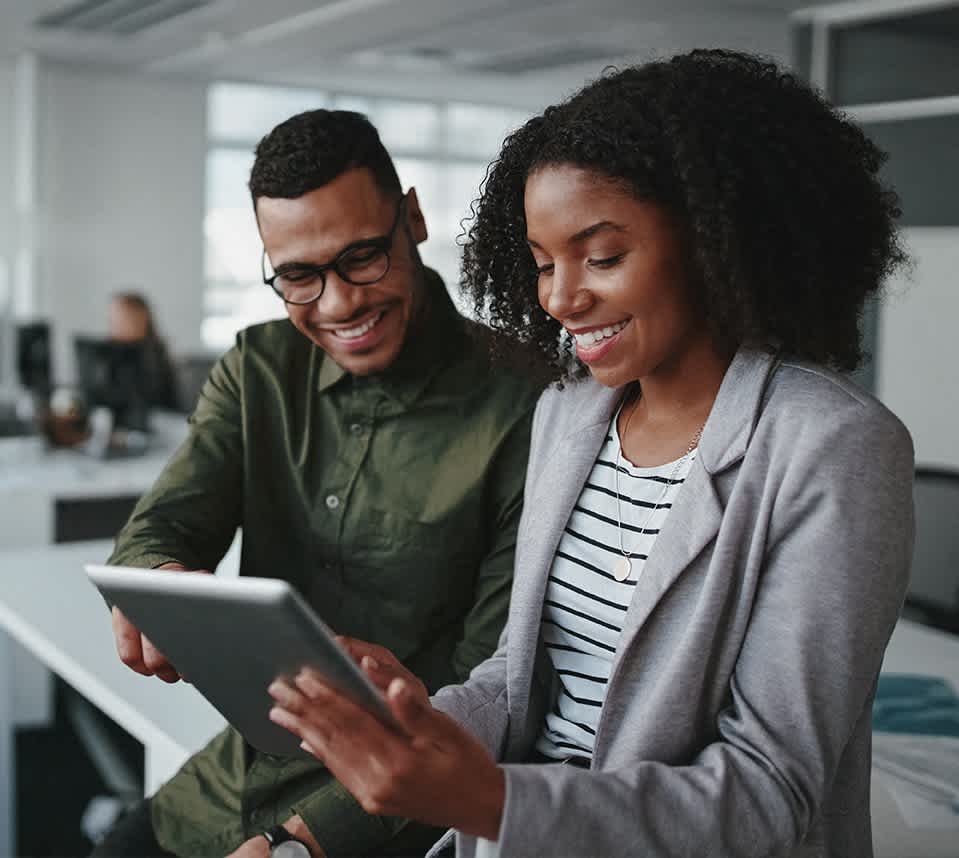 two people looking at a tablet computer in an office