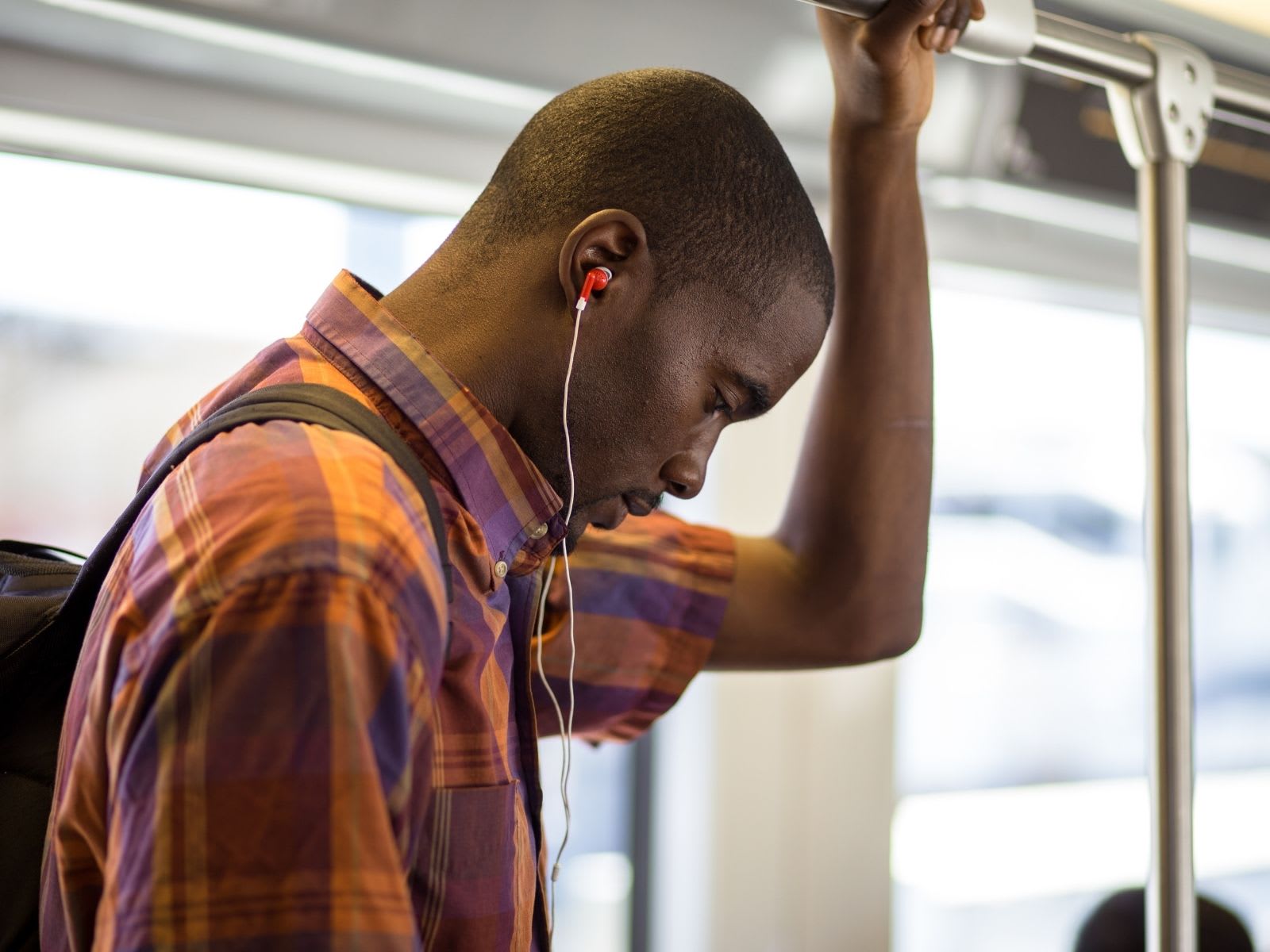 Male student on bus wearing headphones