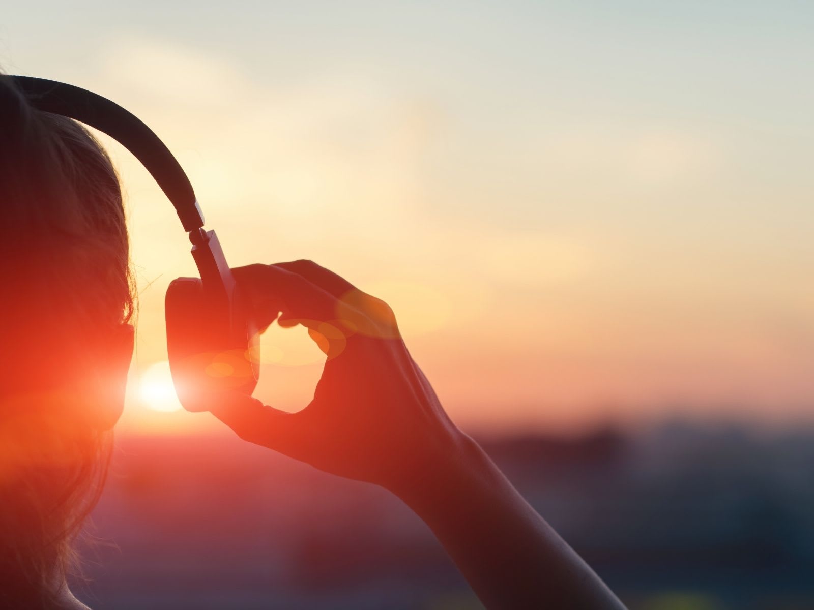 Female wearing headphones looking at the sunset