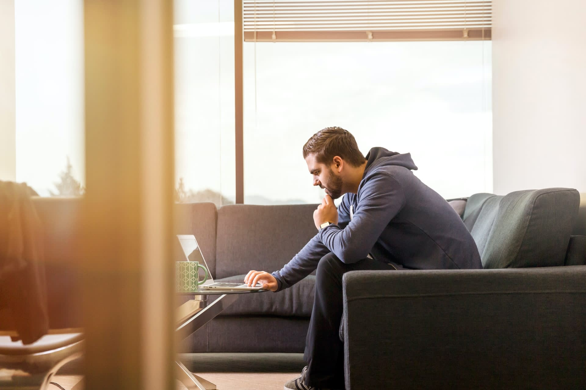 Man on laptop sitting on sofa