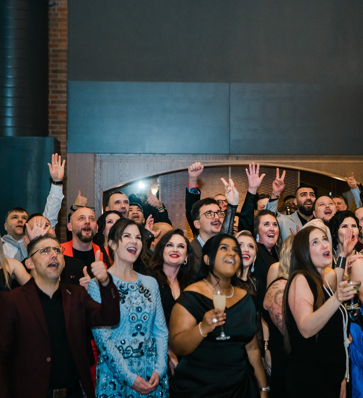 A group of people are celebrating and raising their hands in the air.