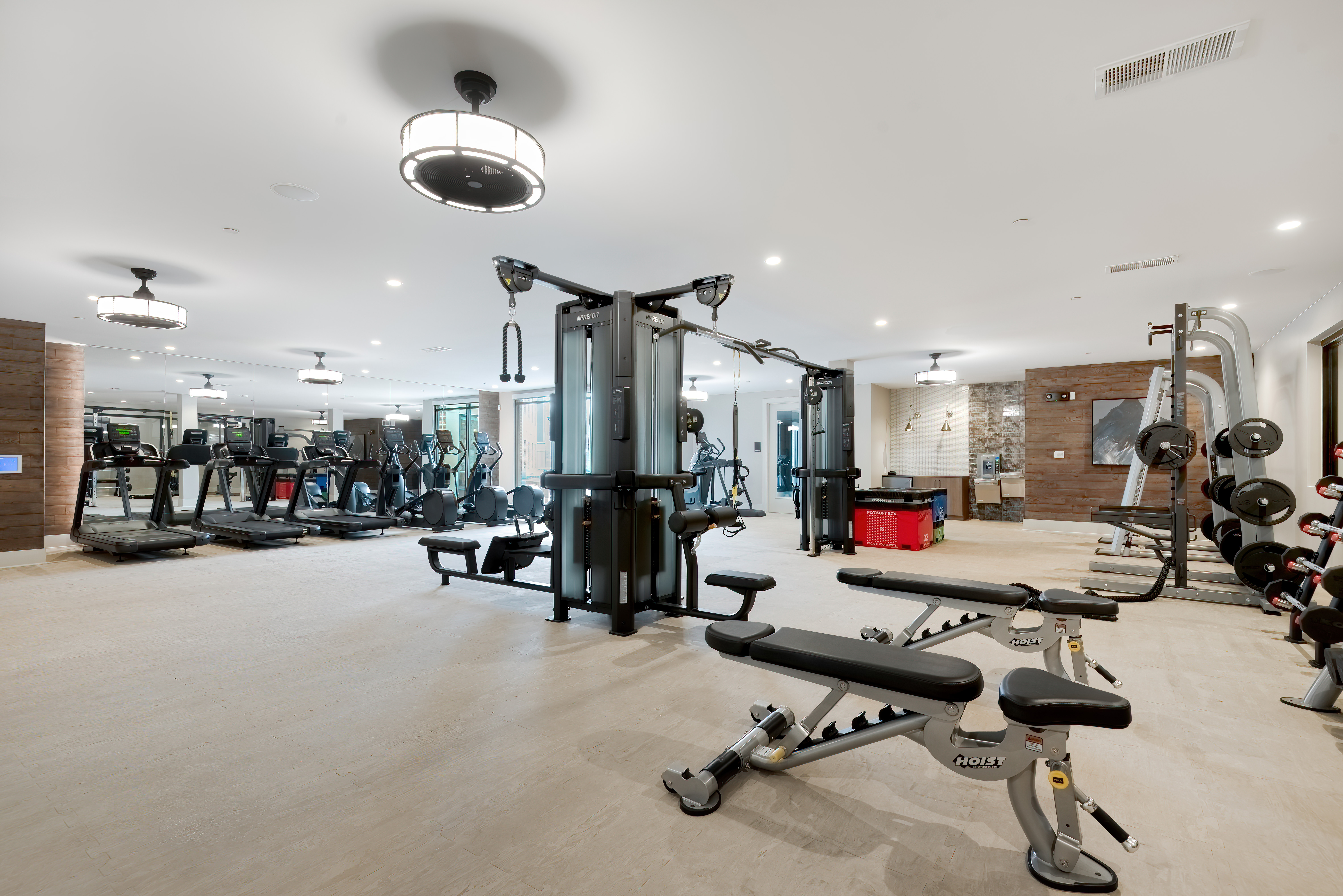 A gym with a variety of equipment including treadmills, weights, and exercise machines.