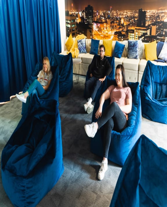a group of people sitting on top of a blue couch