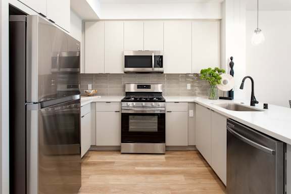 A modern kitchen with white cabinets and stainless steel appliances.