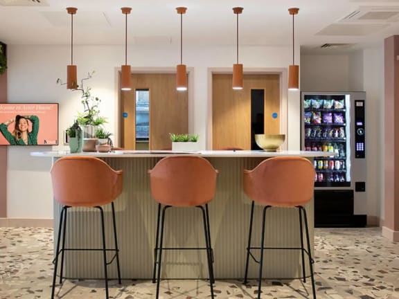 a kitchen with three bar stools in front of a counter