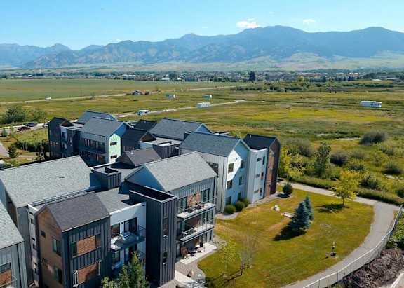 A large building complex with a mountain range in the background.