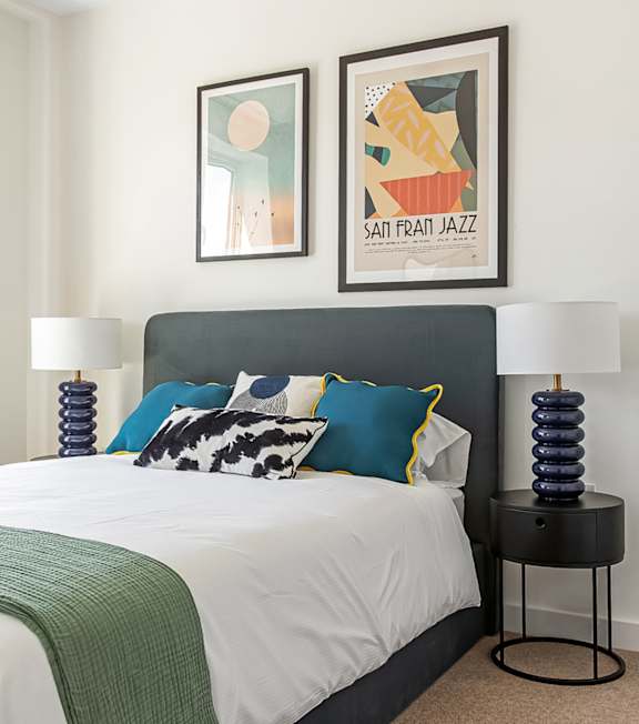 a bedroom with a bed and pictures on the wall