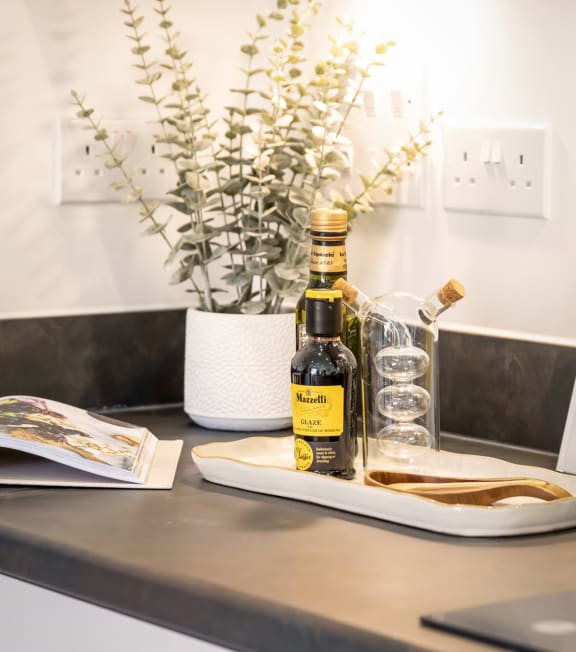 a kitchen counter with a bottle of whisky and a glass on it