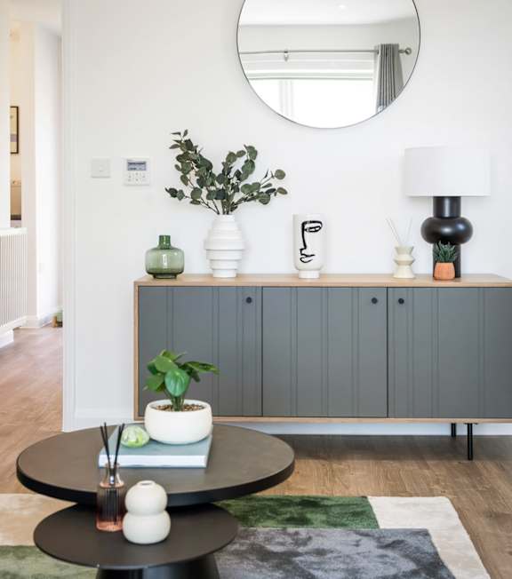 a living room with a table and a mirror