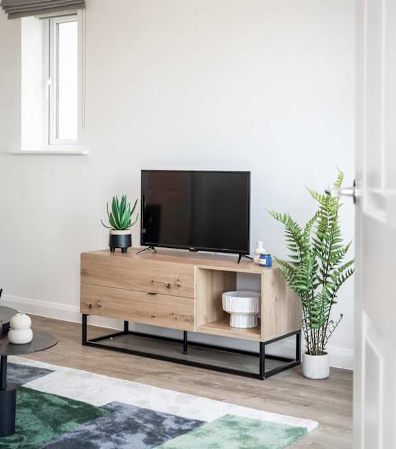 a living room with a tv on a wooden stand