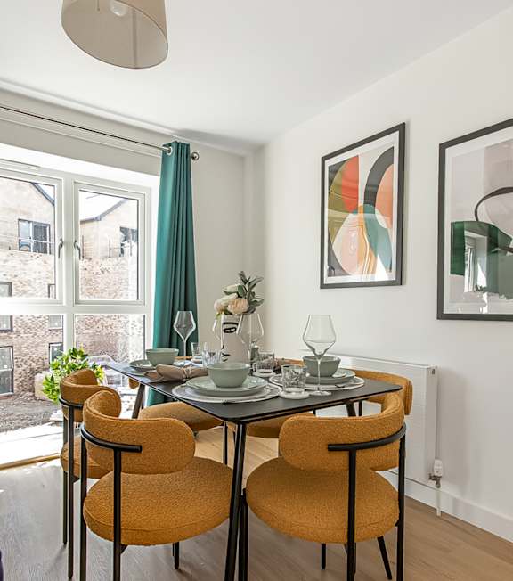 a dining room with a table and chairs and a window