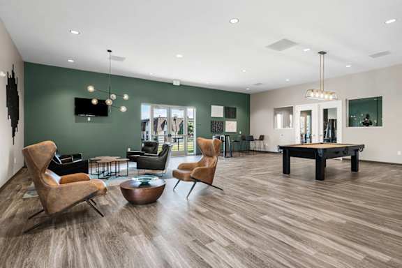 A living room with a wooden floor and a green wall.