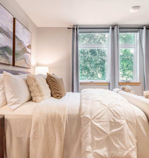 A bedroom with a large bed and a painting on the wall.